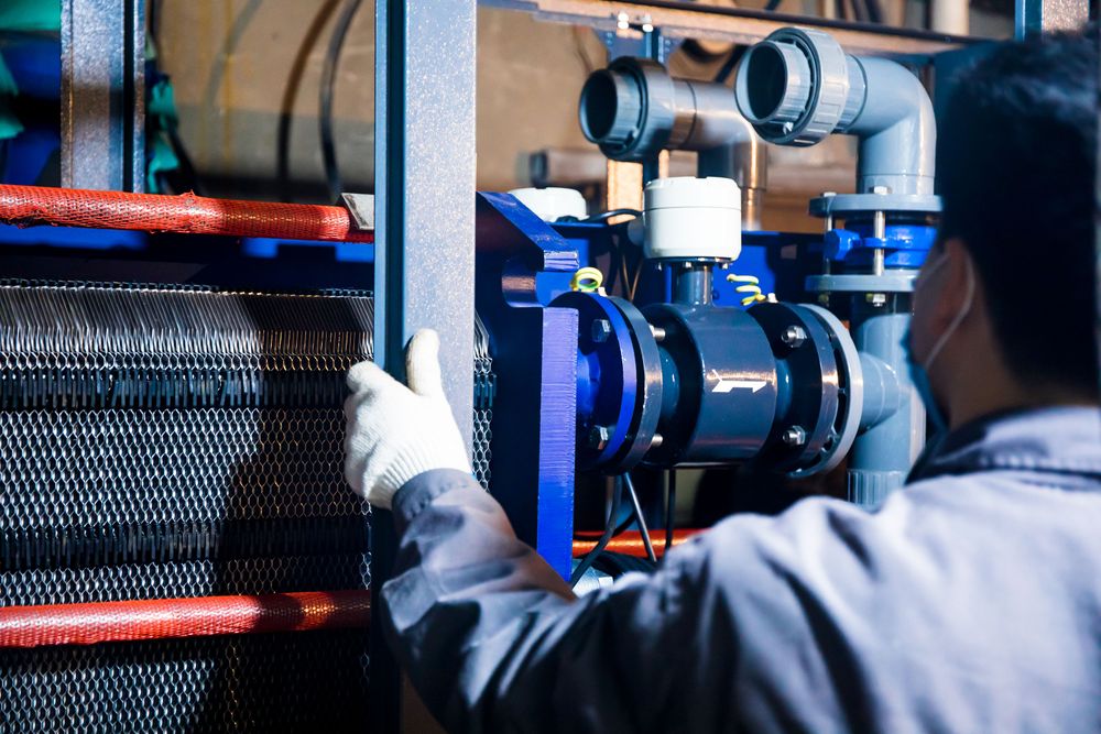 A technician inspecting valves and industrial mechanical equipment